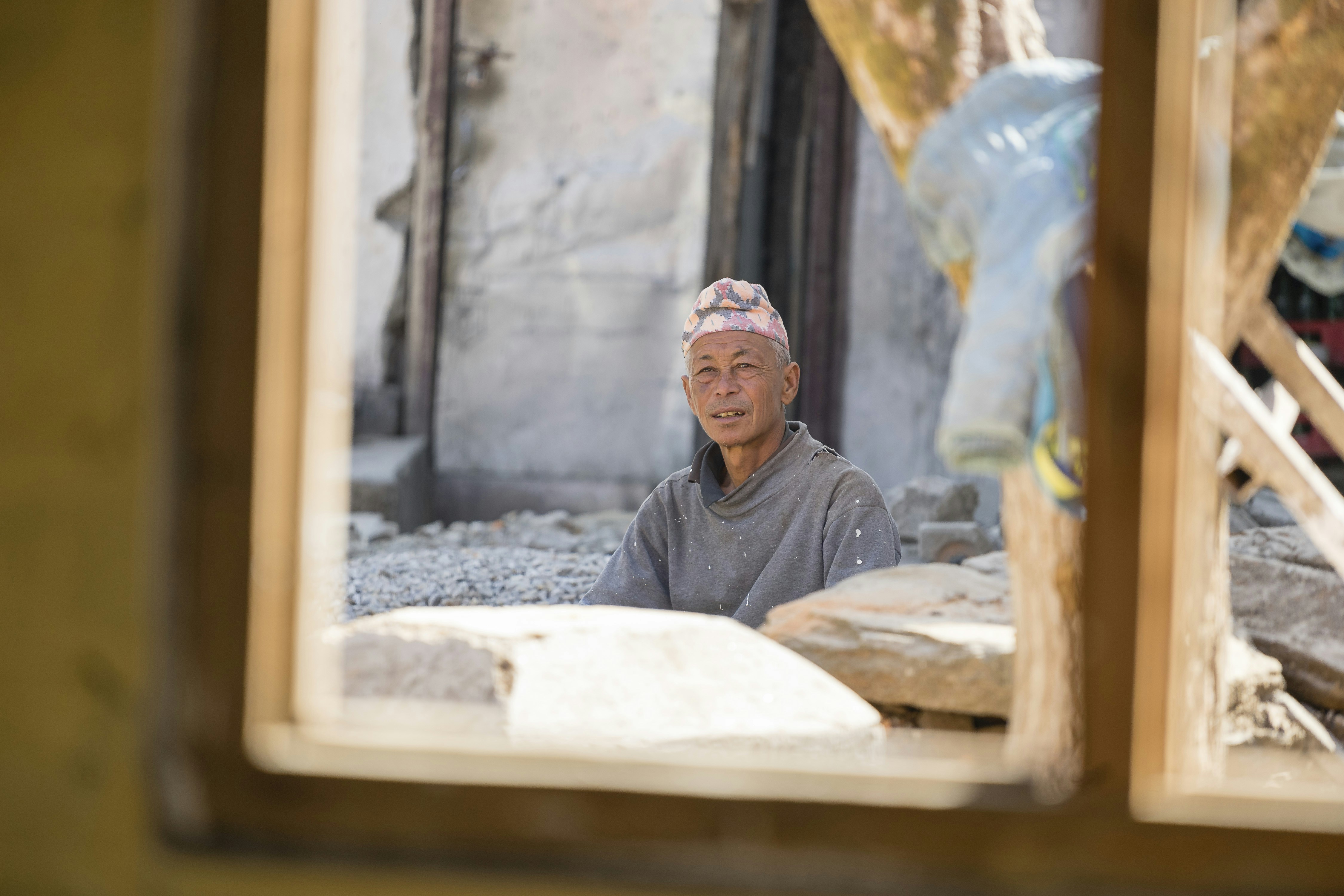 uomo in maglione grigio in piedi fuori dalla finestra
