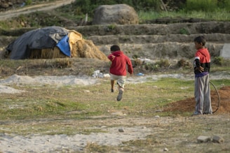 Two kids jumping in the air, showcasing their trendy clothing.