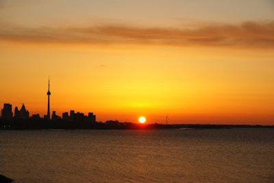 A serene sunset over the London skyline with the Shard silhouetted against the orange sky.