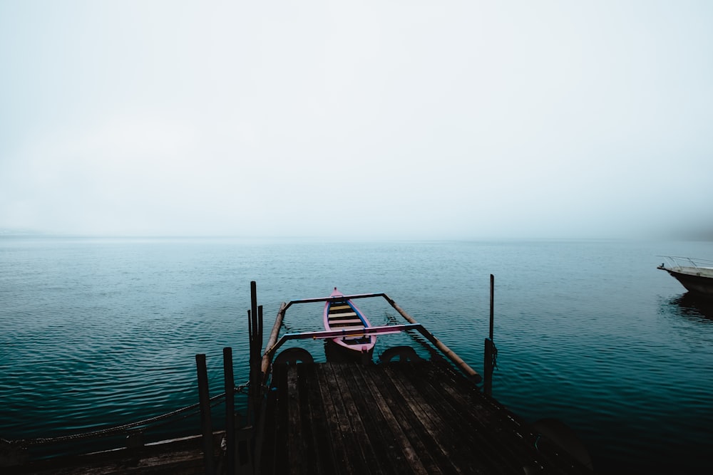 white and blue boat on body of water