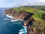 sea cliff under cloudy sky during daytime