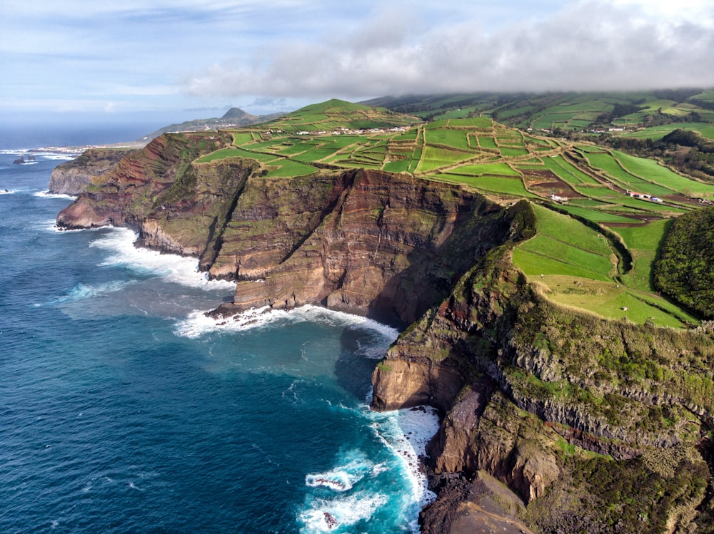 sea cliff under cloudy sky during daytime