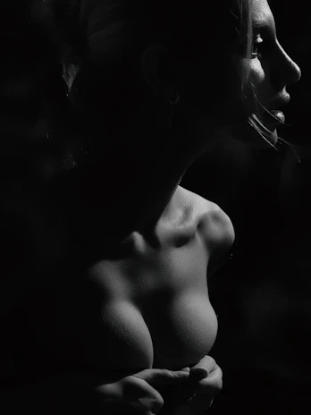 A cinematic portrait of Stella in a sophisticated black outfit, her face partly in shadow with dramatic lighting highlighting her serene expression.