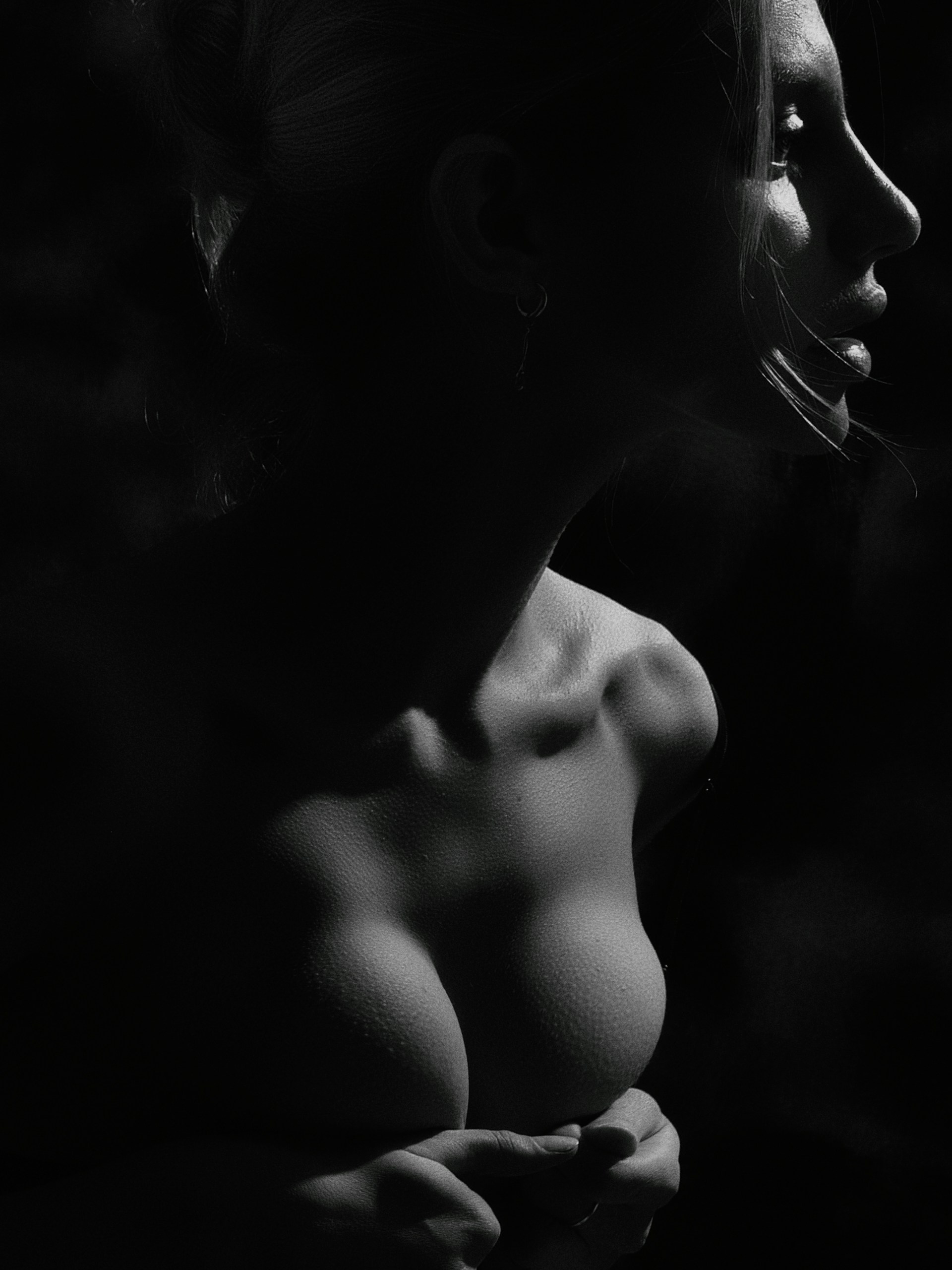 A striking black and white portrait of a model draped in flowing fabric, captured with dramatic shadows that highlight the textures and emotion.