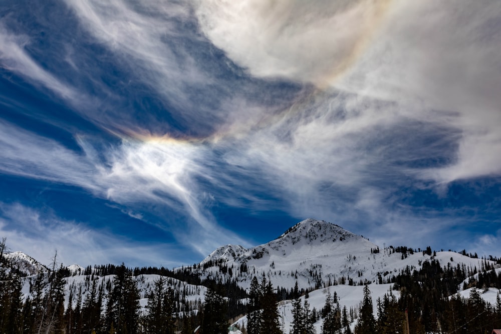 mountain covered with snow under blue and white skies