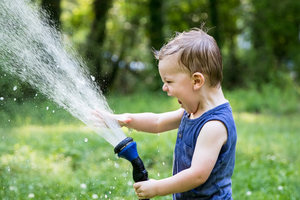 enfant en bas âge jouant à l’eau