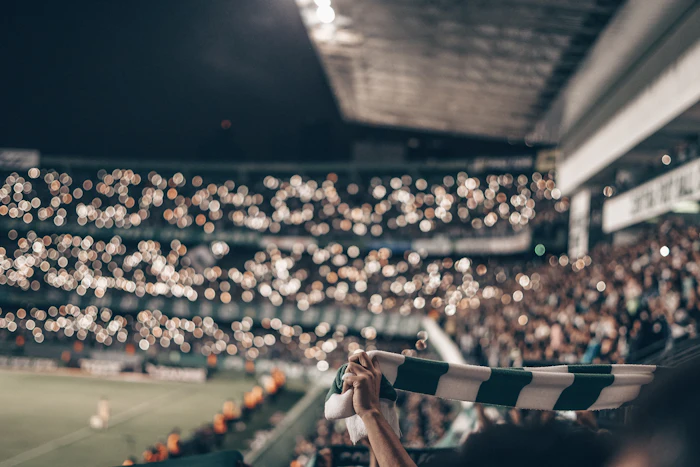 Fan holding up a green and white striped football jersey representing World Cup merchandise culture