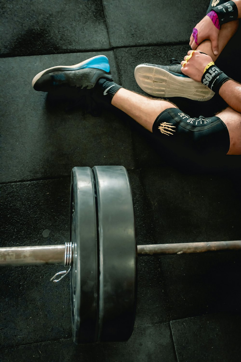 person sitting beside barbell