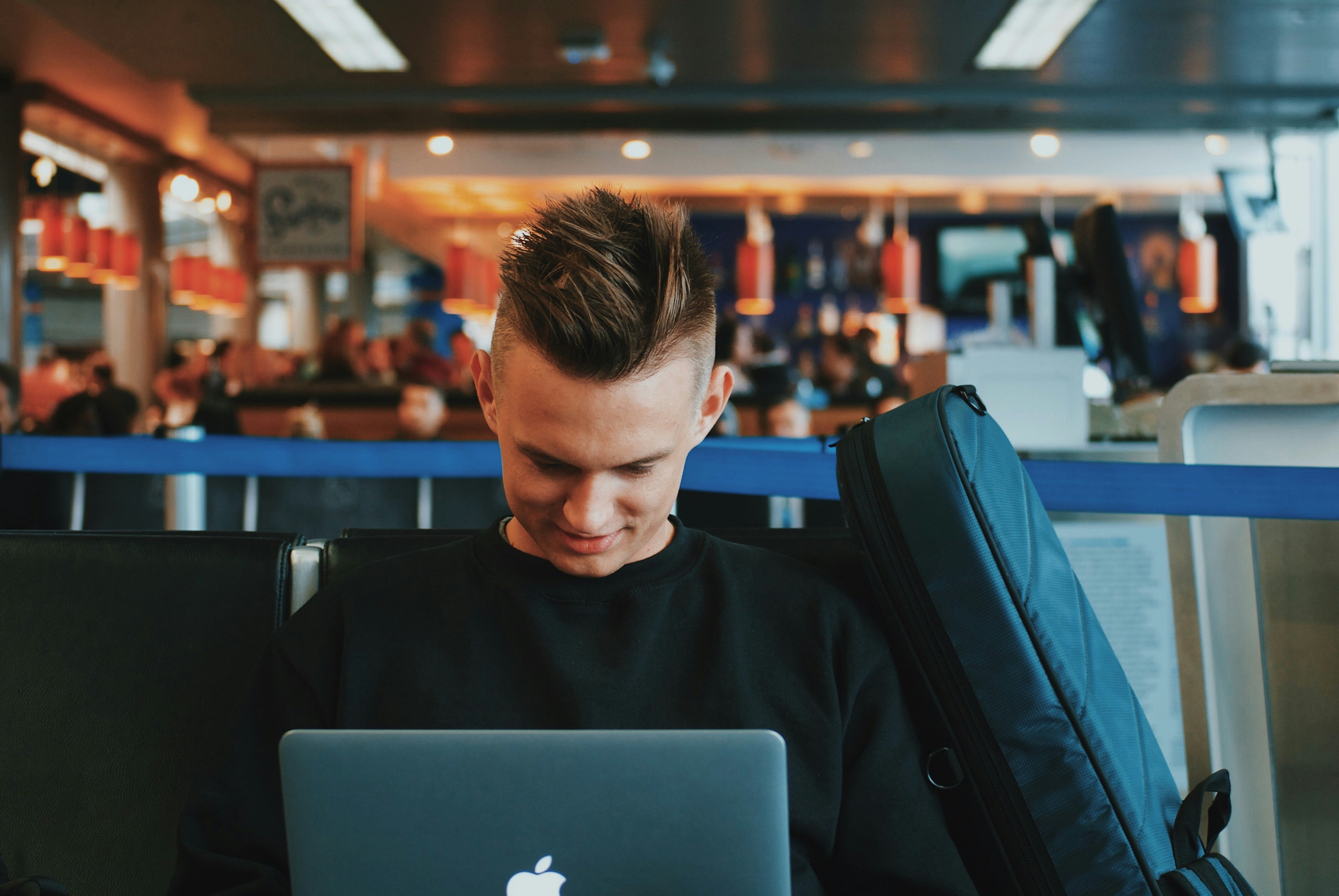 smiling man facing Apple MacBook