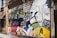 A vibrant mural painted on the exterior wall of a building. The mural features bold graphics and text related to social justice and civil rights. It includes an image of a person using a large video camera, surrounded by various text excerpts about rights and justice. The words 'KNOW YOUR RIGHTS' are prominently displayed on the mural. The artwork is a mix of colorful geometric shapes and monochrome drawings of people.