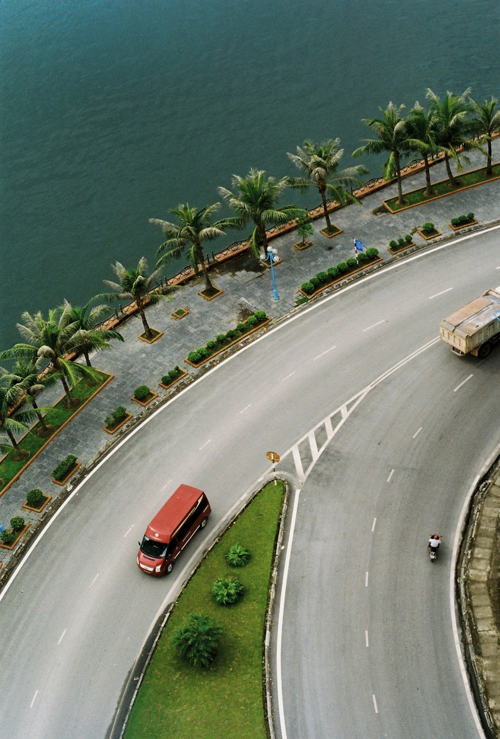 red vehicle in road during daytime