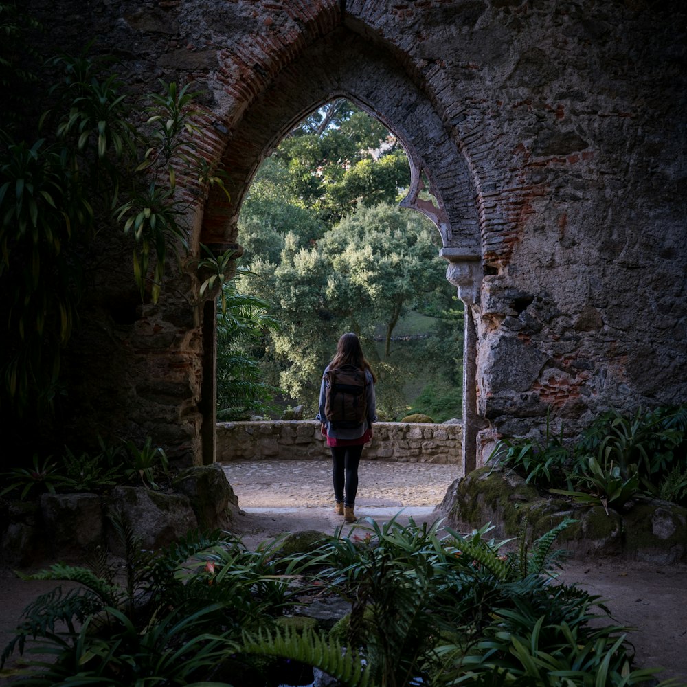 person standing under concrete arch