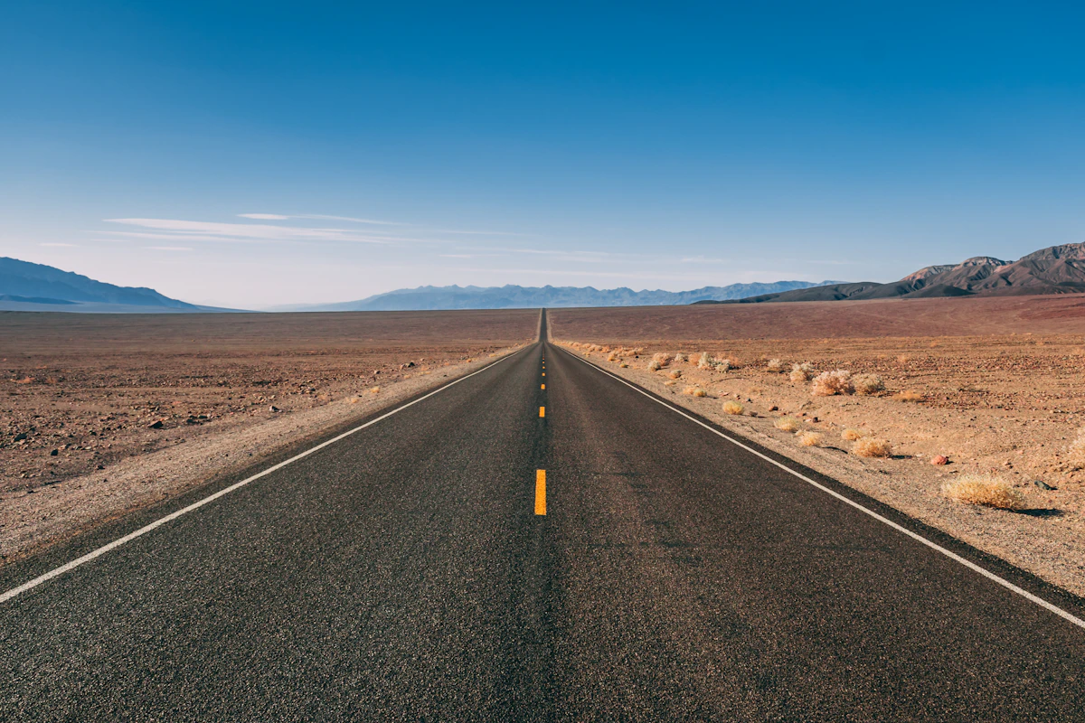 Long desert highway under clouds