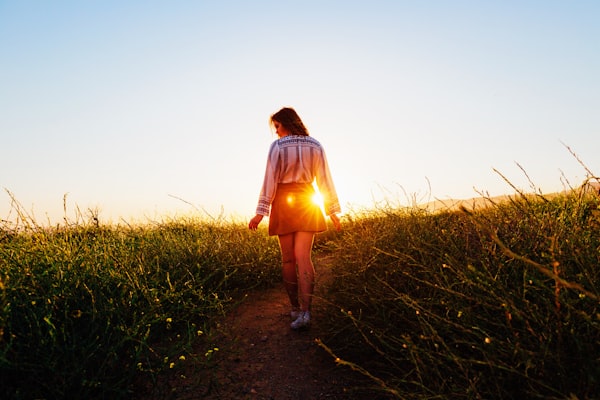 Woman walking on a pathway at sunset