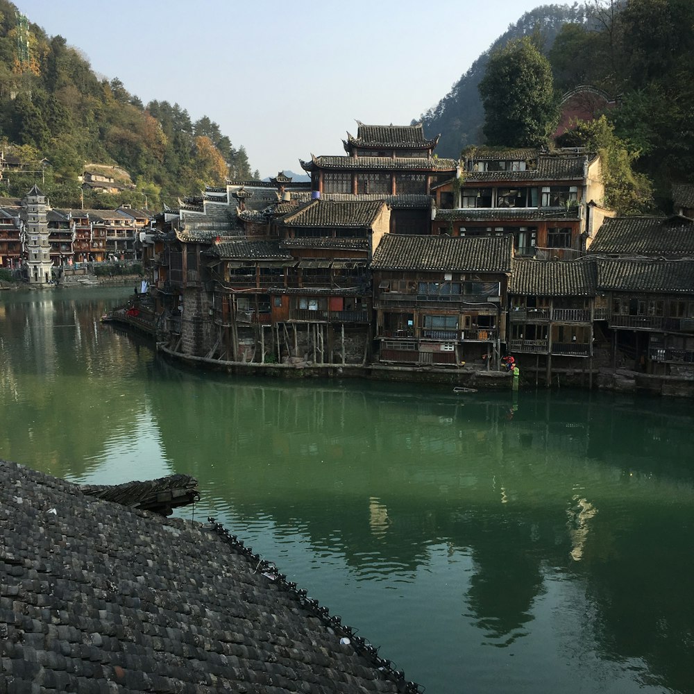 brown and gray houses near calm body of water during daytime