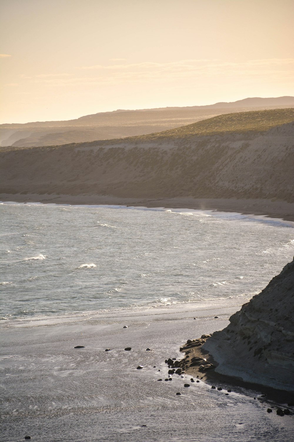 cliff fronting the sea under grey sky