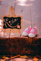 Close-up of tiny baby shoes next to a handwritten welcome sign.
