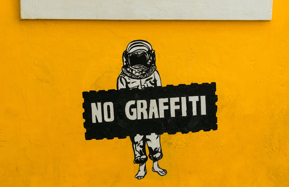 no graffiti sign on yellow painted wall