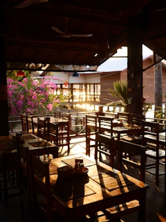 Cozy restaurant terrace overlooking the lush landscapes of Ruta de las Flores at sunset.