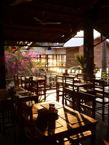 Cozy restaurant terrace overlooking the lush landscapes of Ruta de las Flores at sunset.