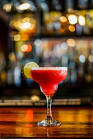 Close-up of a handcrafted cocktail illuminated by soft red lighting.