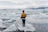 Smiling traveler standing on a glacier with a stunning icy landscape behind.