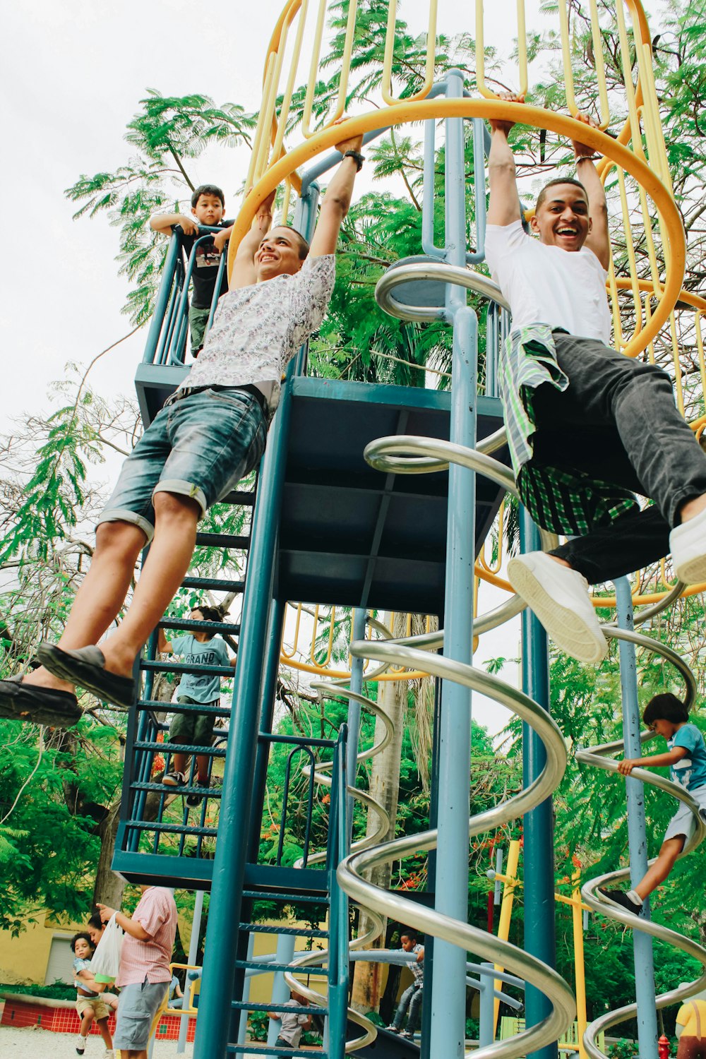 homem brincando no escorregador do playground