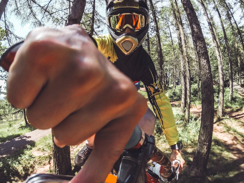 man biking surrounded with tall and green trees