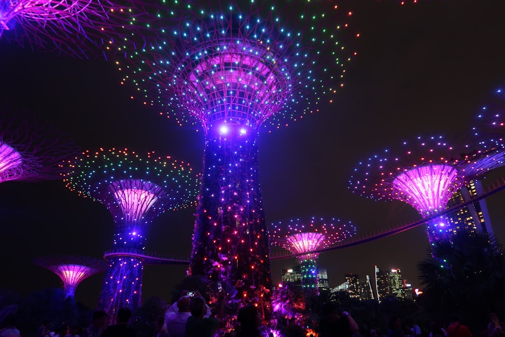 a group of people standing around a tree filled with lights