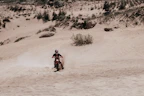 A powerful red dirt bike kicking up dust on a rugged trail