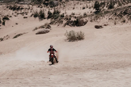 An action shot of a motorcycle kicking up dust on a dirt trail during off-roading.