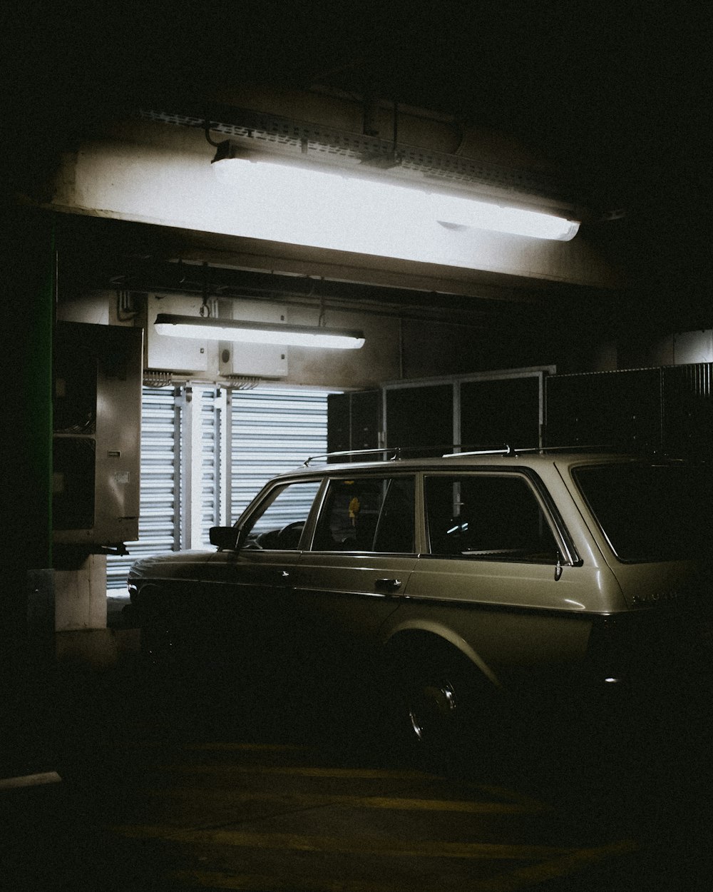 gray car parked beside shutter door