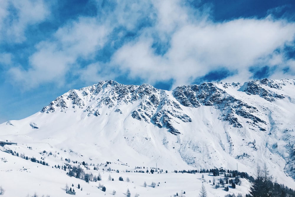 mountain covered with snow under white and blue skies