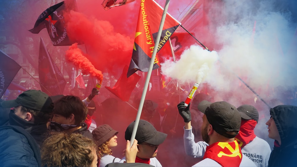 people celebrating with flags and white-and-red smokes