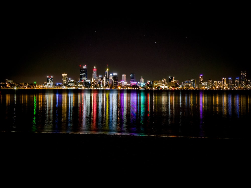 city lights reflecting on harbor at nighttime