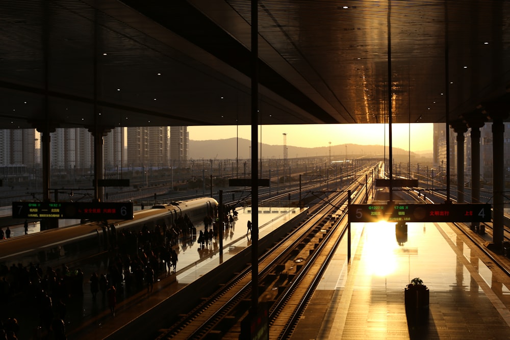 people waiting for train at the station during sunset