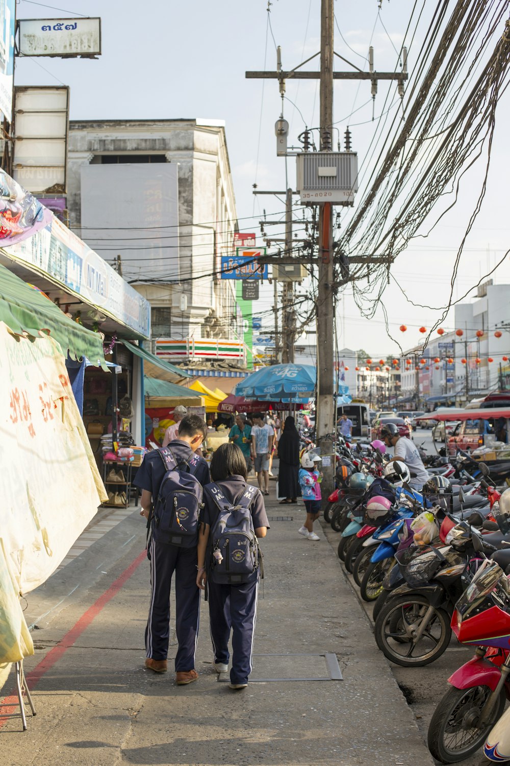 boy and girl walking beside motorcycles