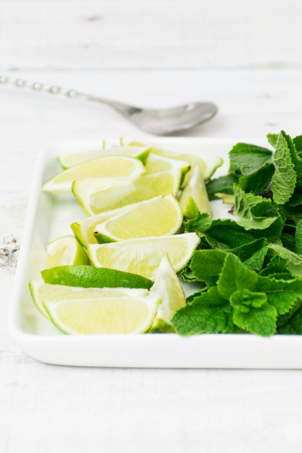 mint leaves beside cut up  lime slices