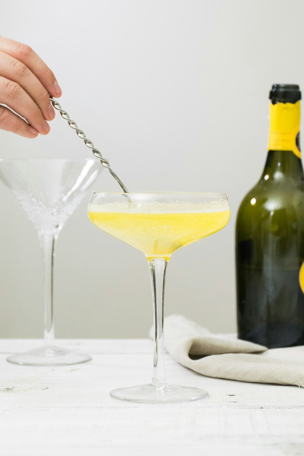 yellow liquid in clear footed glass cup