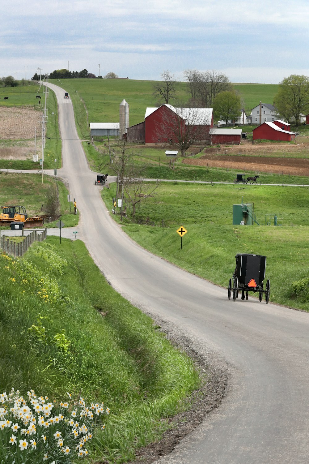 gray concrete pavement beside green grass fields