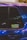 A close-up of a car window featuring a sticker with the text 'IACRO TEAM'. The car's paint appears to have an iridescent quality, reflecting various shades under the light. The window shows some reflections and blurred lights in the background.