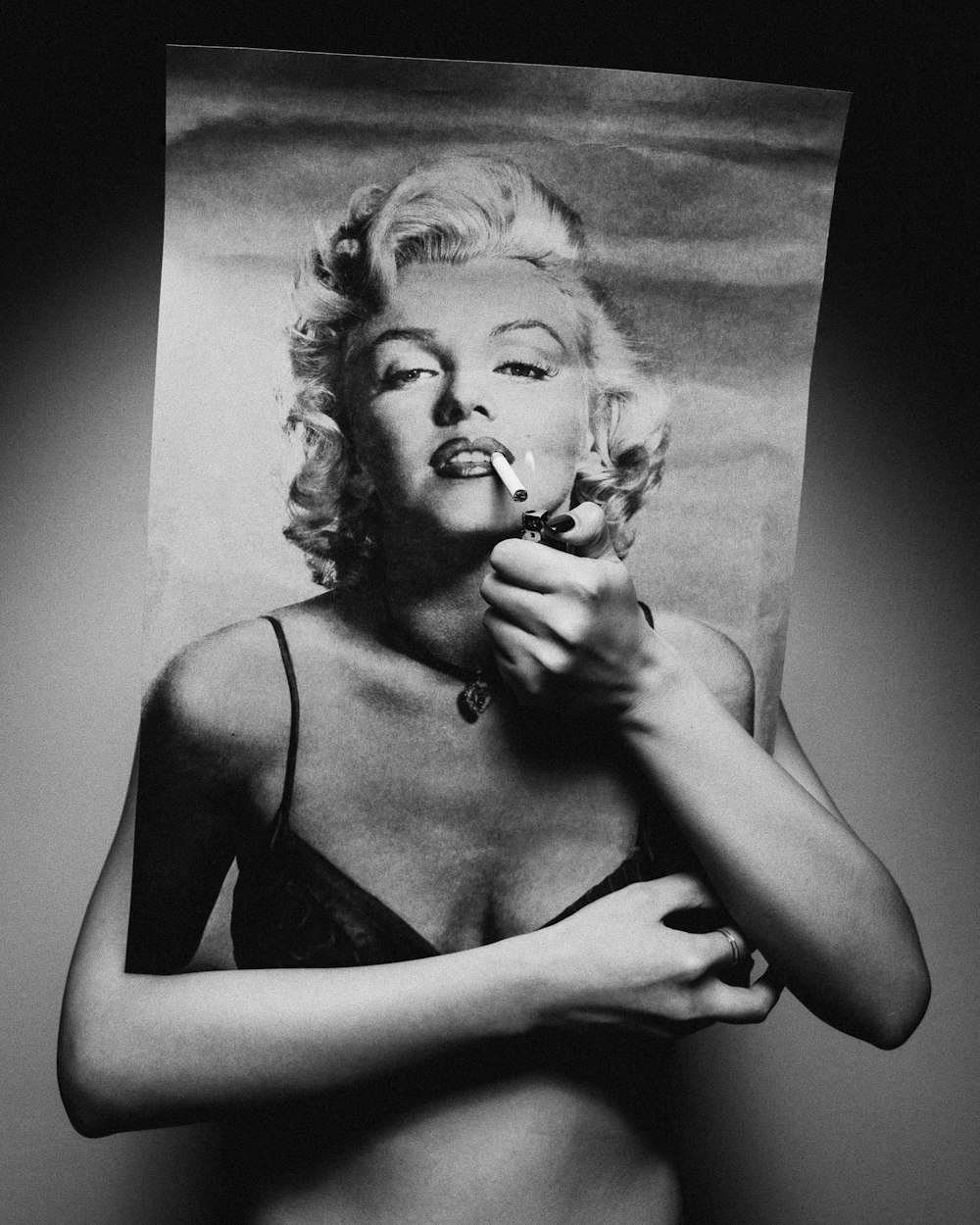 persona che tiene il poster di Marilyn Monroe che copre il viso