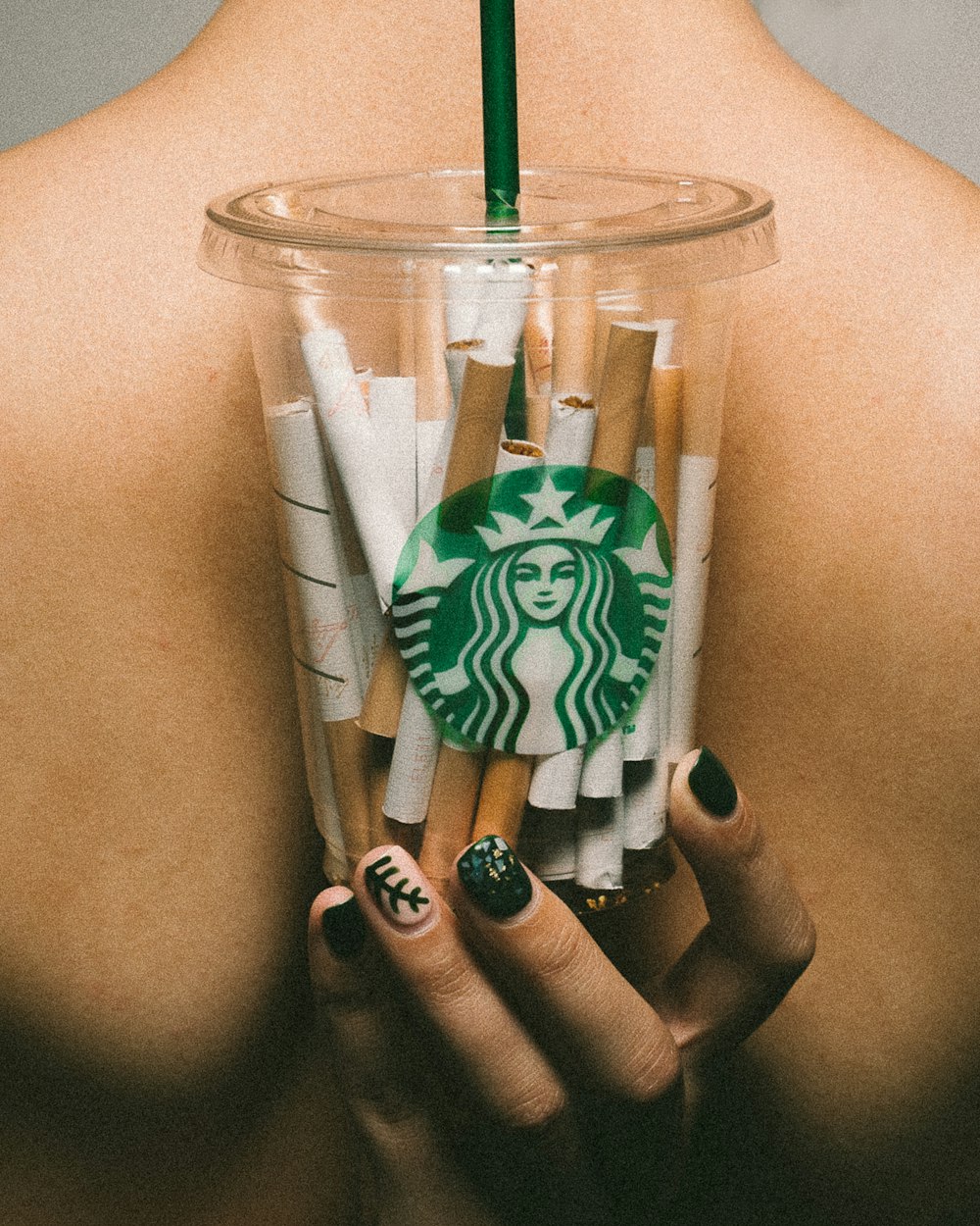 cigarette sticks inside clear Starbucks cup with lid and straw