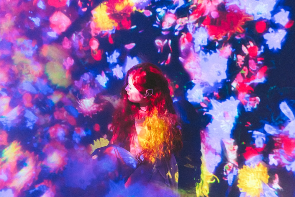 Une femme debout devant un fond coloré