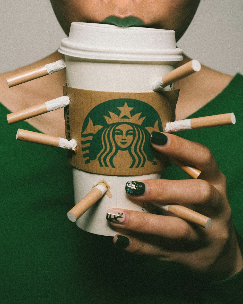 white Starbucks coffee cup surrounded with cigarette sticks