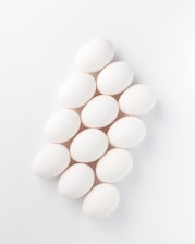 twelve white eggs on white surface