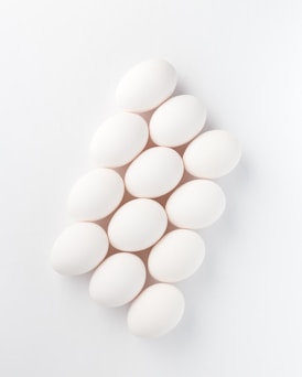 twelve white eggs on white surface
