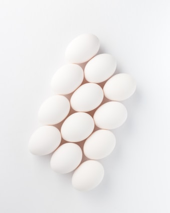 twelve white eggs on white surface
