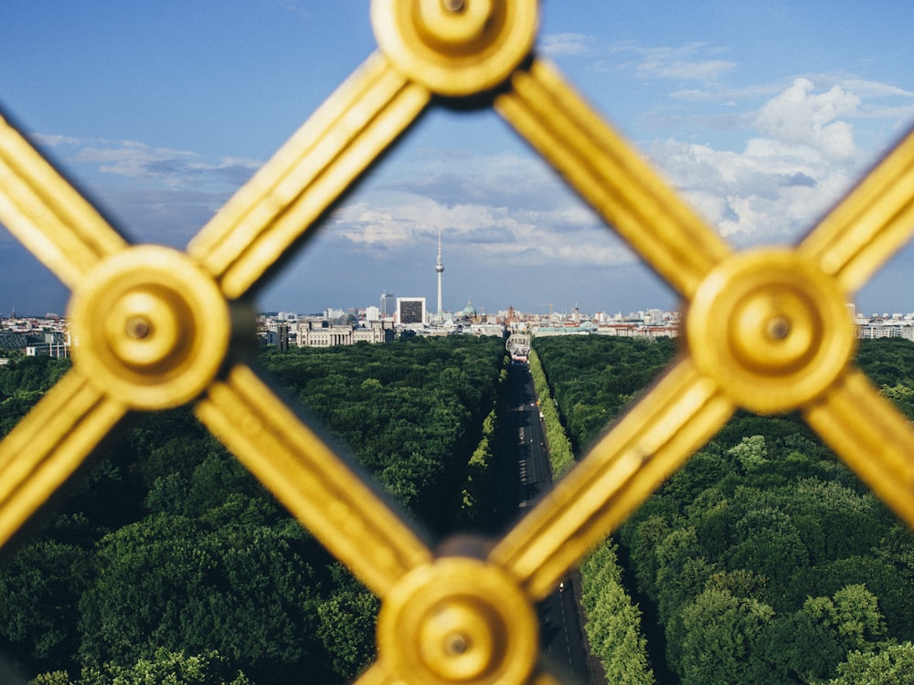 Fotografía de gran angular de la ciudad durante el día a través de una valla metálica amarilla