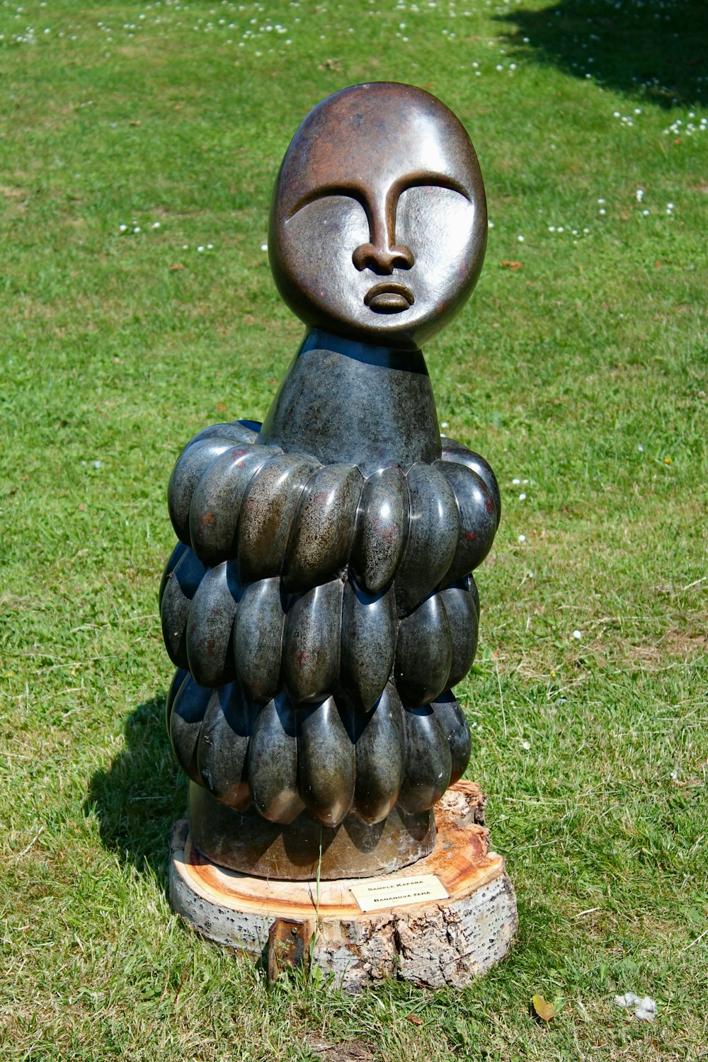 brown wooden garden sculpture on green grass